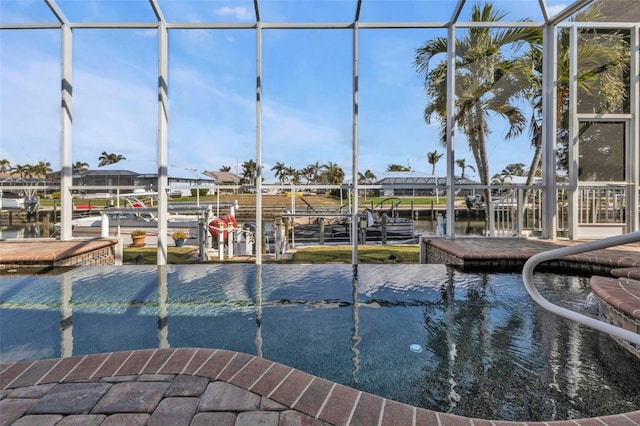 view of swimming pool featuring a lanai, a water view, and a boat dock