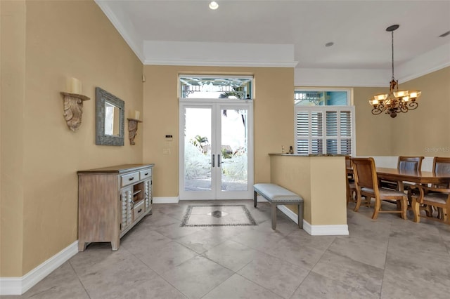 foyer with a notable chandelier, ornamental molding, light tile patterned flooring, and french doors