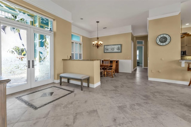 entryway with ornamental molding, french doors, and an inviting chandelier