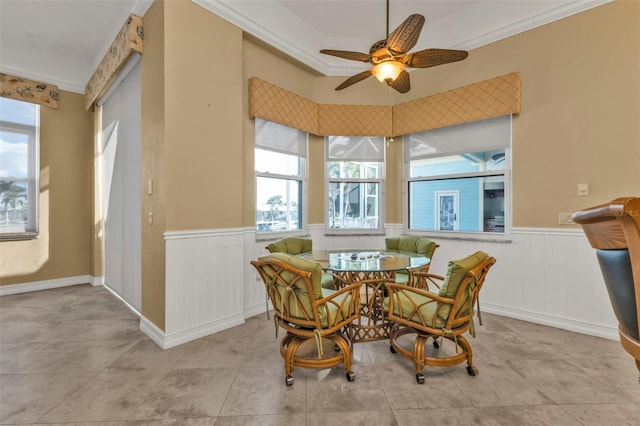 tiled dining room with ceiling fan, crown molding, and breakfast area