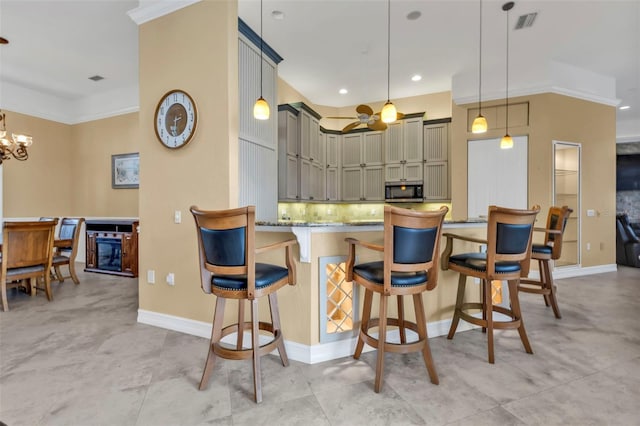 kitchen featuring decorative light fixtures, an inviting chandelier, gray cabinets, light stone counters, and a breakfast bar area