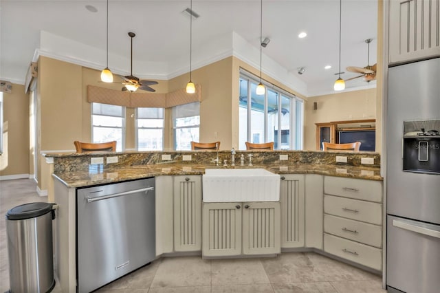 kitchen with dark stone countertops, sink, appliances with stainless steel finishes, crown molding, and pendant lighting