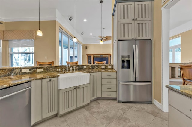 kitchen with dark stone countertops, sink, decorative light fixtures, crown molding, and stainless steel appliances