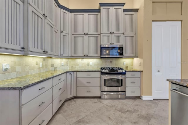 kitchen featuring appliances with stainless steel finishes, tasteful backsplash, gray cabinetry, light stone counters, and light tile patterned flooring