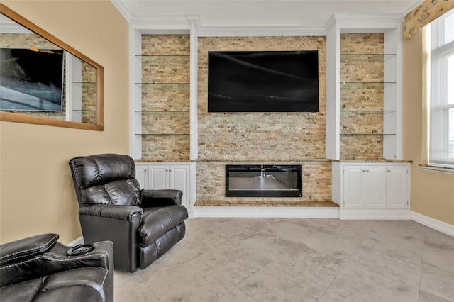 living room featuring a fireplace, ornamental molding, and built in features