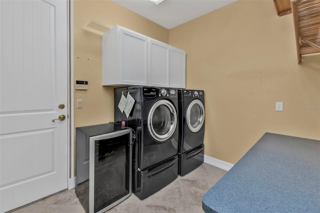 clothes washing area featuring washing machine and dryer, light tile patterned flooring, cabinets, and beverage cooler