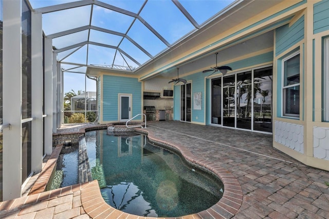 view of pool with a patio, an outdoor kitchen, a lanai, and ceiling fan