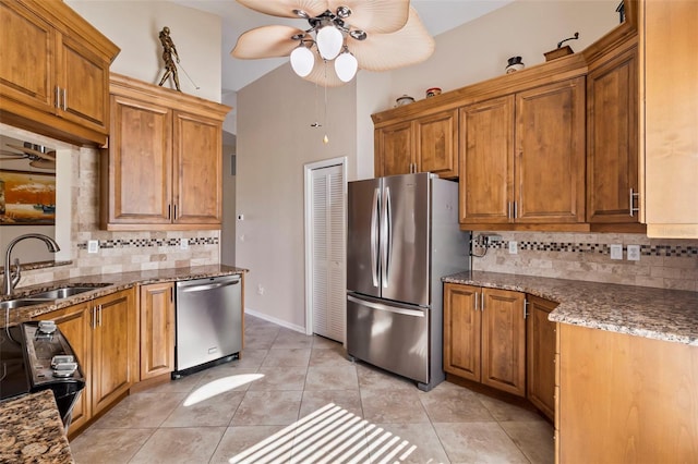 kitchen featuring light tile patterned flooring, appliances with stainless steel finishes, sink, backsplash, and ceiling fan