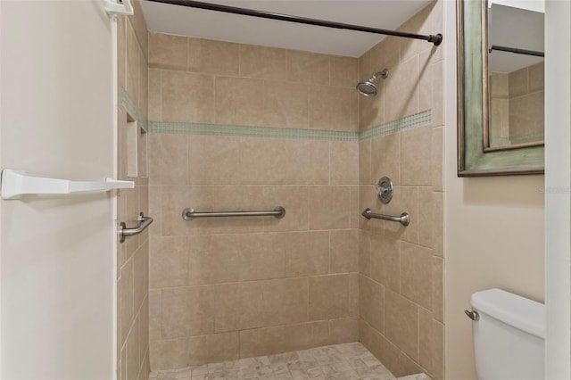 bathroom featuring tiled shower and toilet