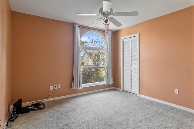 unfurnished bedroom with light carpet, ceiling fan, and a closet