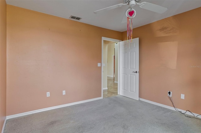 carpeted spare room with ceiling fan