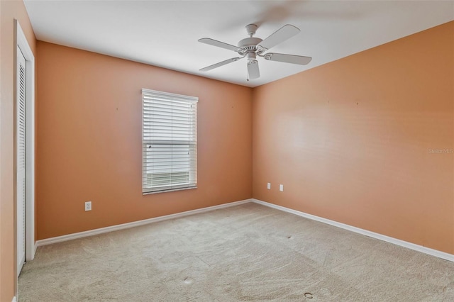 carpeted spare room featuring ceiling fan