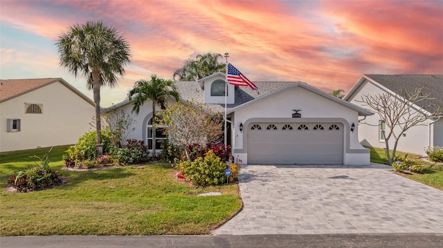 view of front facade featuring a garage and a lawn