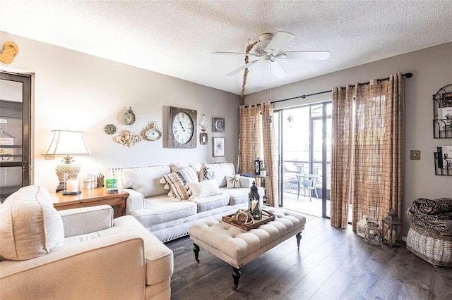 living room with a textured ceiling, dark wood-type flooring, and ceiling fan