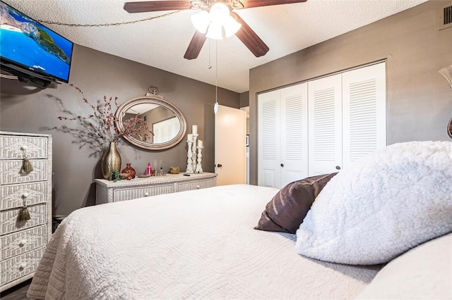 bedroom with a textured ceiling, a closet, and ceiling fan