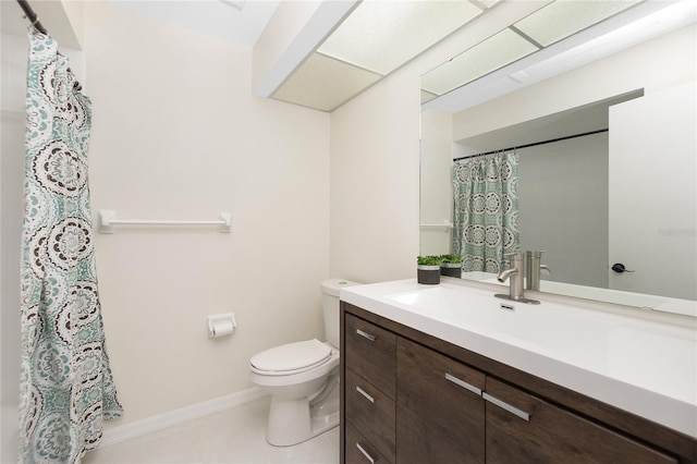 bathroom with tile patterned flooring, baseboards, vanity, and toilet