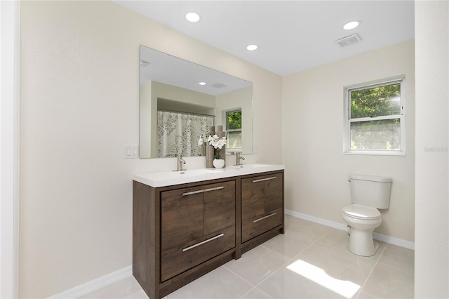 bathroom with a healthy amount of sunlight, visible vents, toilet, and double vanity