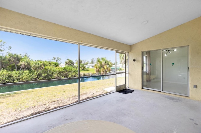 unfurnished sunroom with a water view and vaulted ceiling