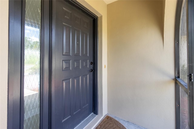 doorway to property featuring stucco siding