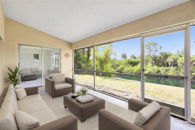 sunroom with vaulted ceiling, a water view, and plenty of natural light