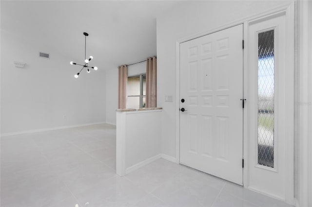 entrance foyer featuring light tile patterned floors, a notable chandelier, visible vents, and baseboards