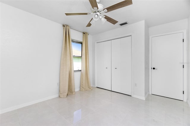 unfurnished bedroom with baseboards, visible vents, ceiling fan, and a closet