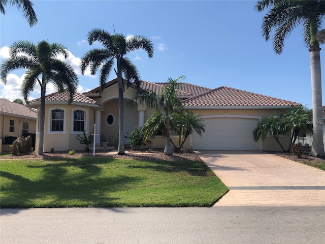 mediterranean / spanish home with a garage and a front yard