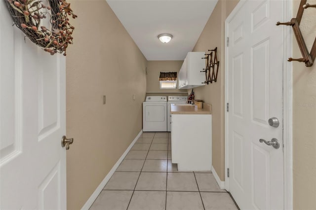 washroom with cabinets, washer and dryer, and light tile patterned floors