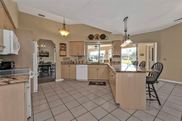 kitchen with a breakfast bar area, hanging light fixtures, light tile patterned floors, light brown cabinets, and white appliances