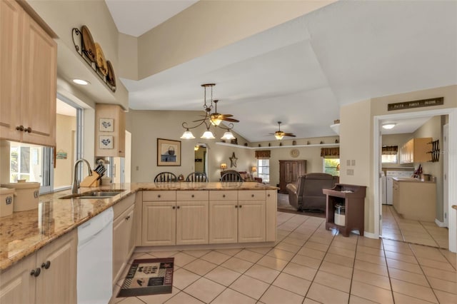 kitchen featuring sink, washer and dryer, dishwasher, and light brown cabinets