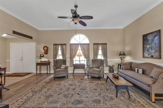 living room featuring hardwood / wood-style flooring, crown molding, and ceiling fan