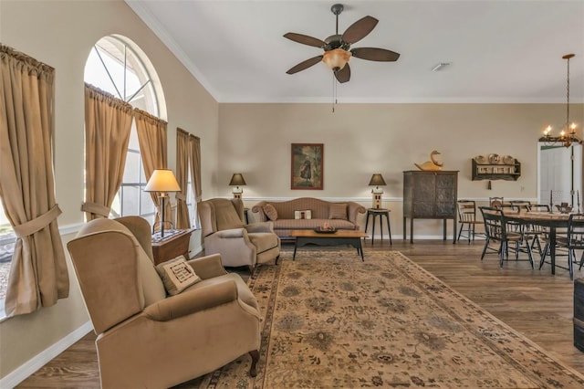 living room featuring crown molding, dark hardwood / wood-style floors, and ceiling fan with notable chandelier