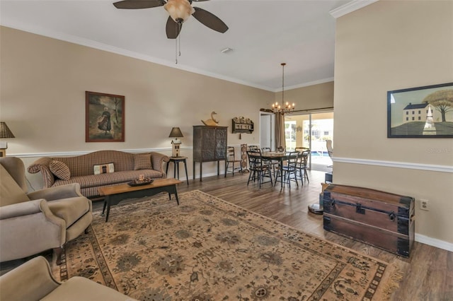 living room with crown molding, wood-type flooring, and ceiling fan with notable chandelier