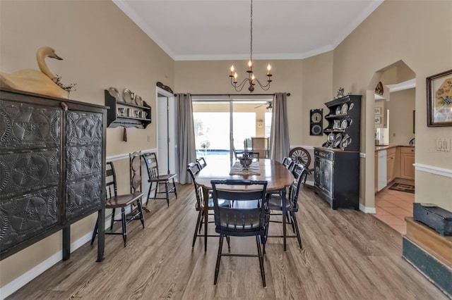 dining room featuring crown molding, a chandelier, and light wood-type flooring