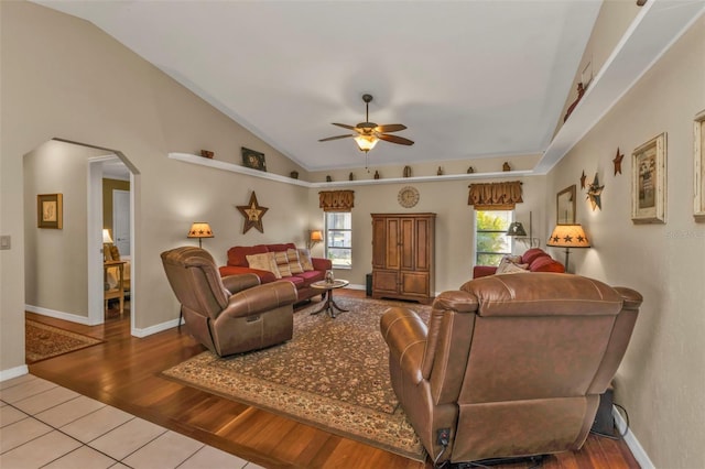 living room with ceiling fan, wood-type flooring, and vaulted ceiling