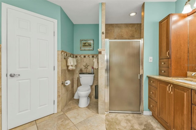 bathroom featuring a shower with door, vanity, tile patterned flooring, and tile walls