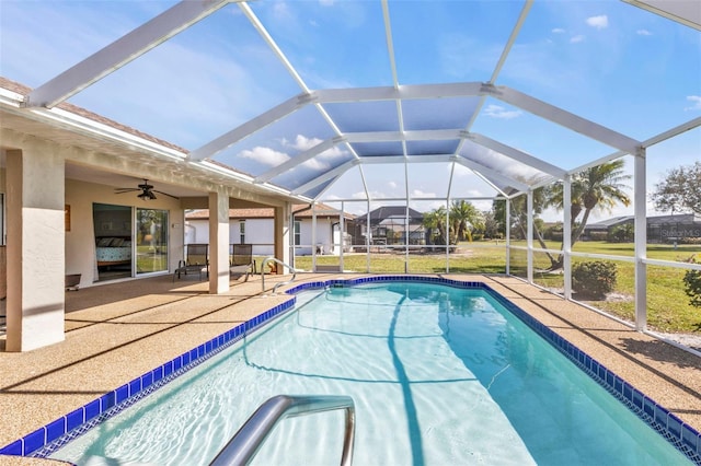 view of swimming pool featuring a patio, ceiling fan, and glass enclosure