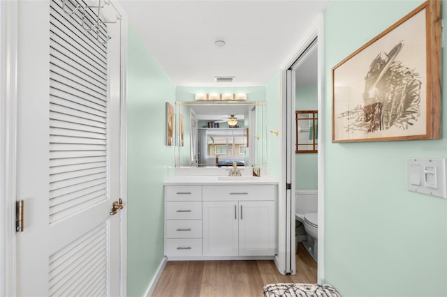 bathroom featuring vanity, toilet, and hardwood / wood-style floors