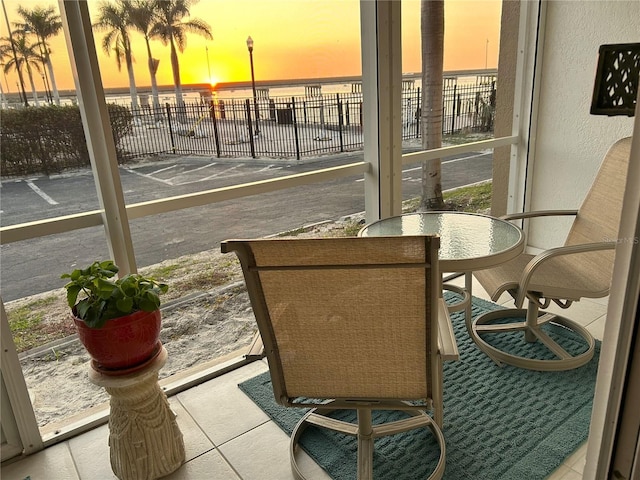 sunroom featuring a water view