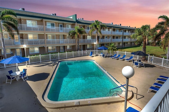 pool at dusk with a patio