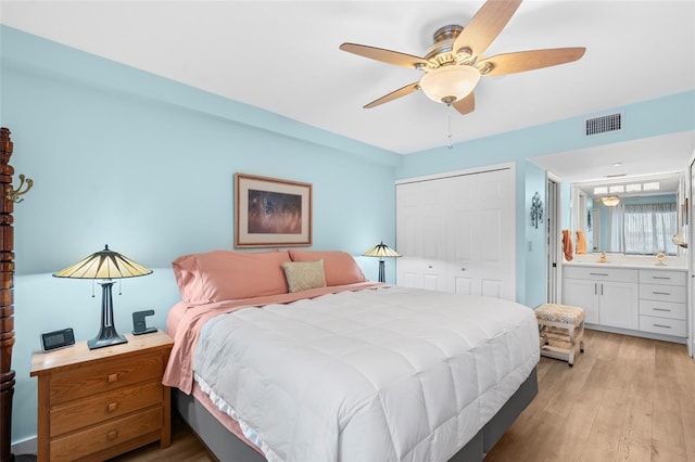 bedroom with connected bathroom, a closet, ceiling fan, and light wood-type flooring