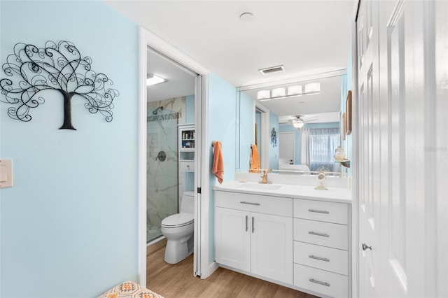 bathroom featuring a shower with door, wood-type flooring, vanity, and toilet