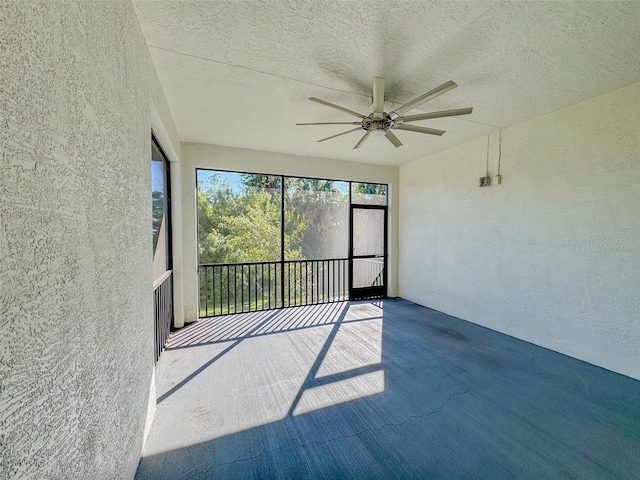 unfurnished sunroom with ceiling fan