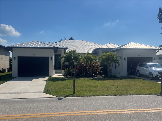 view of front of house with cooling unit, a garage, and a front yard