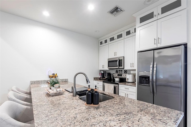 2709 Magdalina Dr Unit 101 102B, Punta Gorda, FL 33950 - kitchen with a peninsula, visible vents, appliances with stainless steel finishes, light stone counters, and a sink