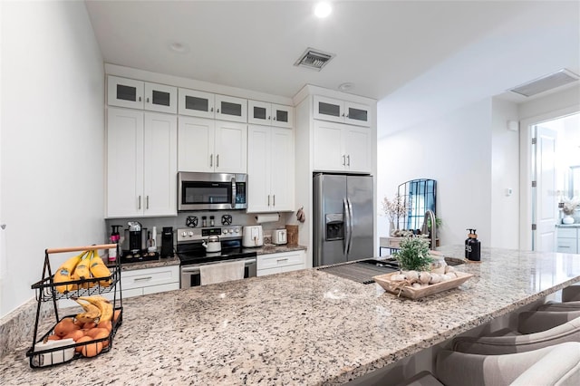 2709 Magdalina Dr Unit 101 102B, Punta Gorda, FL 33950 - kitchen with stainless steel appliances, visible vents, white cabinetry, and light stone counters