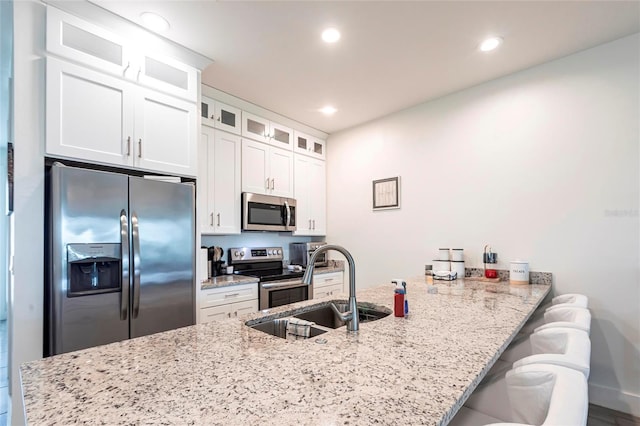 2709 Magdalina Dr Unit 101 102B, Punta Gorda, FL 33950 - kitchen featuring a kitchen breakfast bar, a peninsula, white cabinets, stainless steel appliances, and a sink