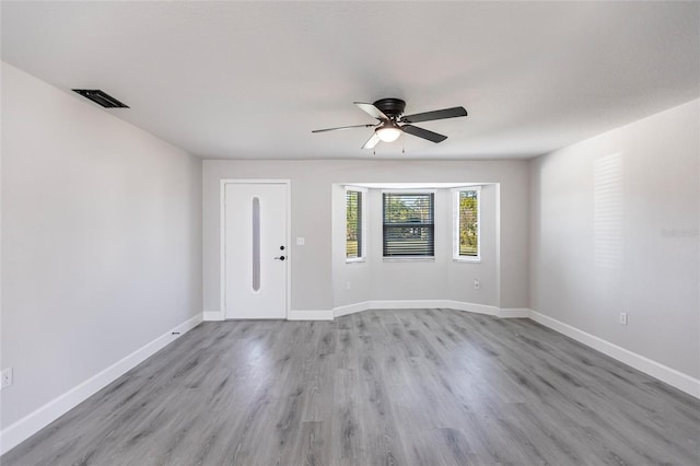 empty room with ceiling fan and light wood-type flooring