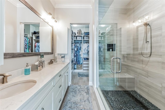 bathroom featuring walk in shower, ornamental molding, vanity, and hardwood / wood-style flooring