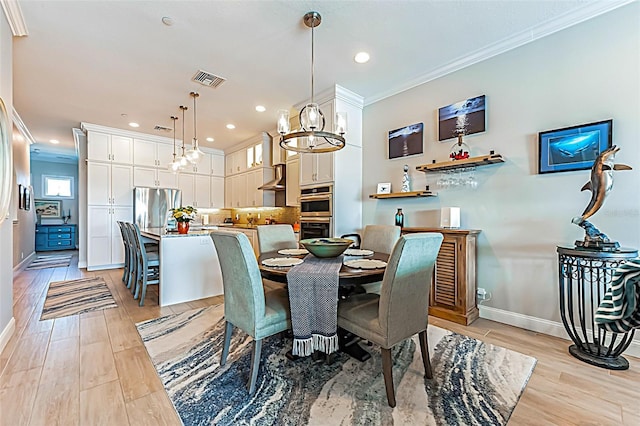 dining room with crown molding, light hardwood / wood-style floors, and a chandelier